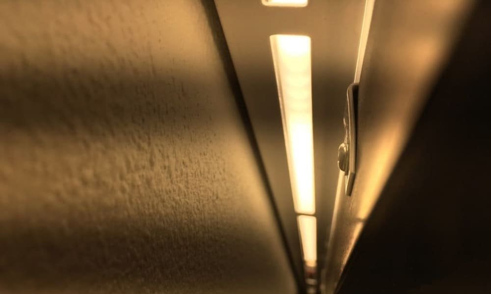 Close-up of an under-cabinet light fixture emitting warm yellow light