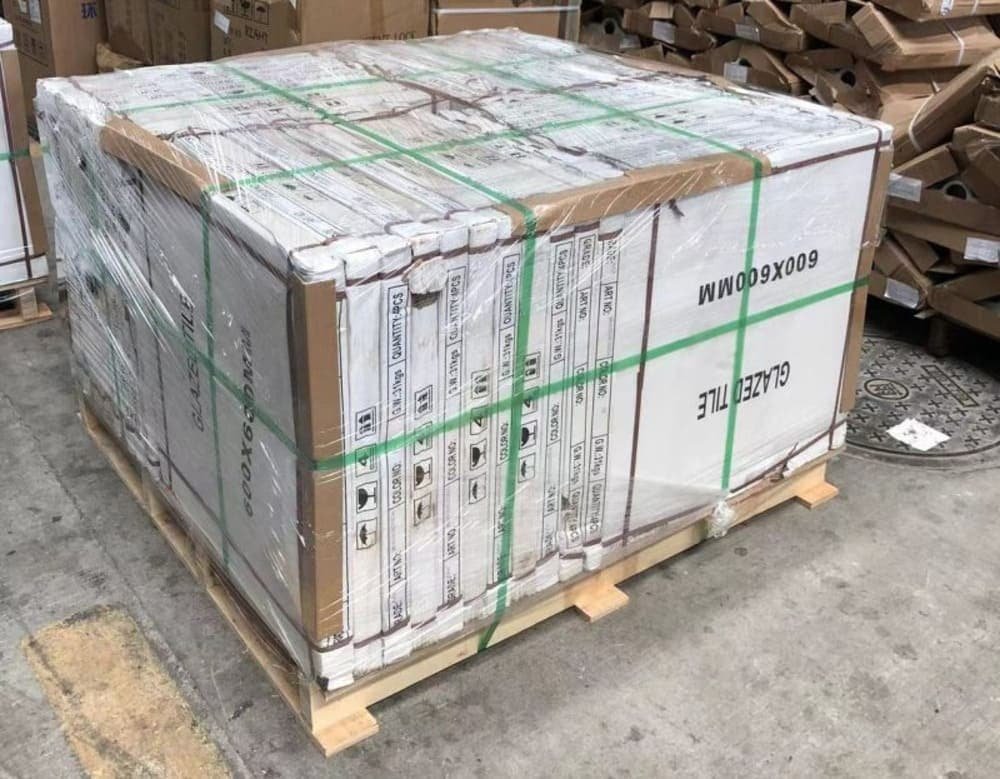 A pallet of glazed tile boxes wrapped in plastic in a warehouse