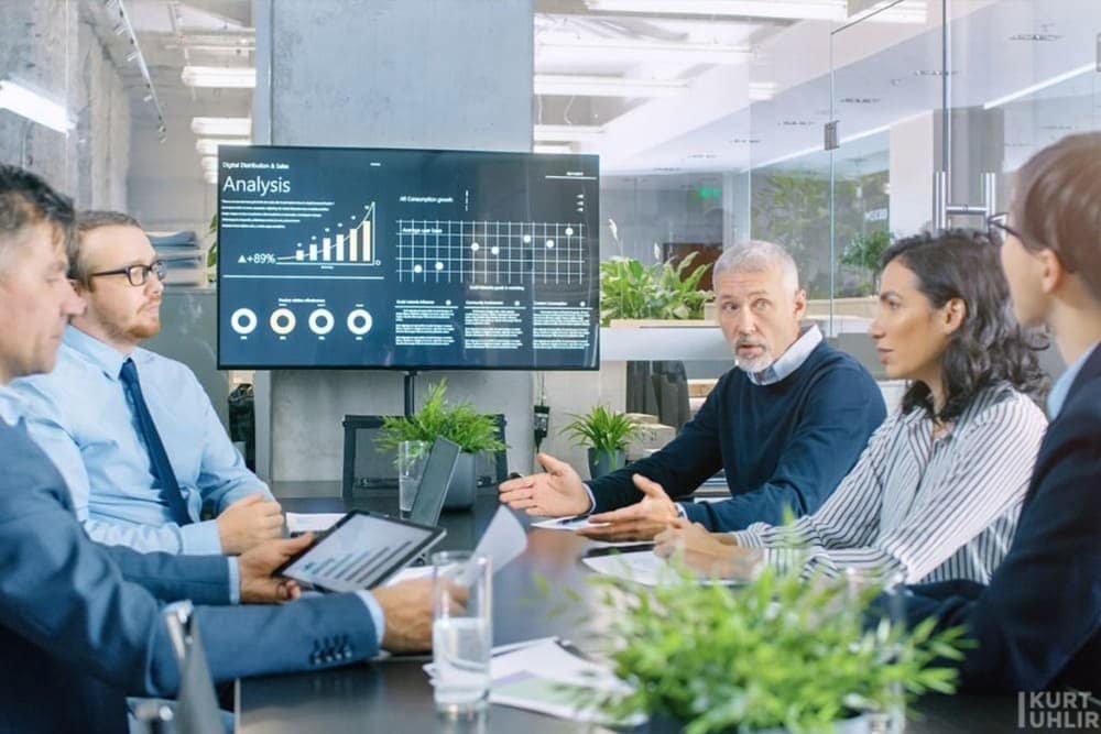 Diverse team discussing data charts in modern conference room