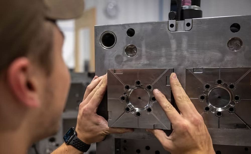 CNC machinist adjusting metal mold with circular patterns
