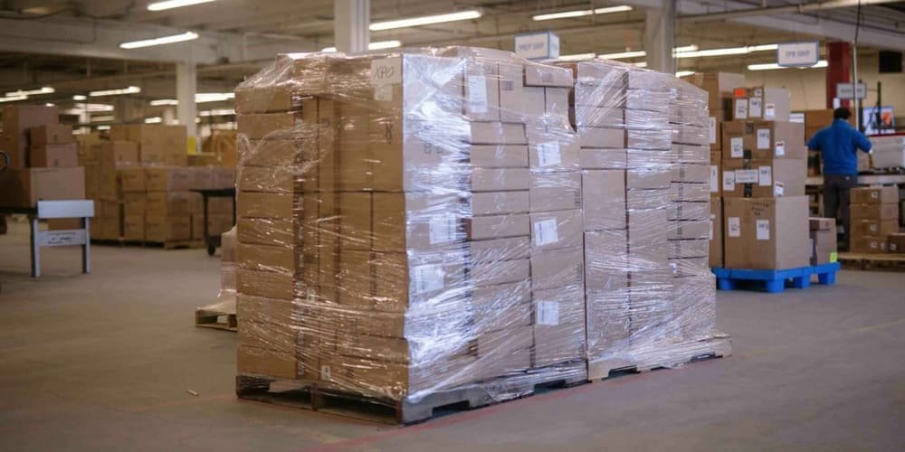 Shrink-wrapped boxes with clear labels on pallets