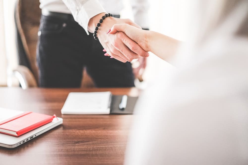 Two business professionals shaking hands in an office setting
