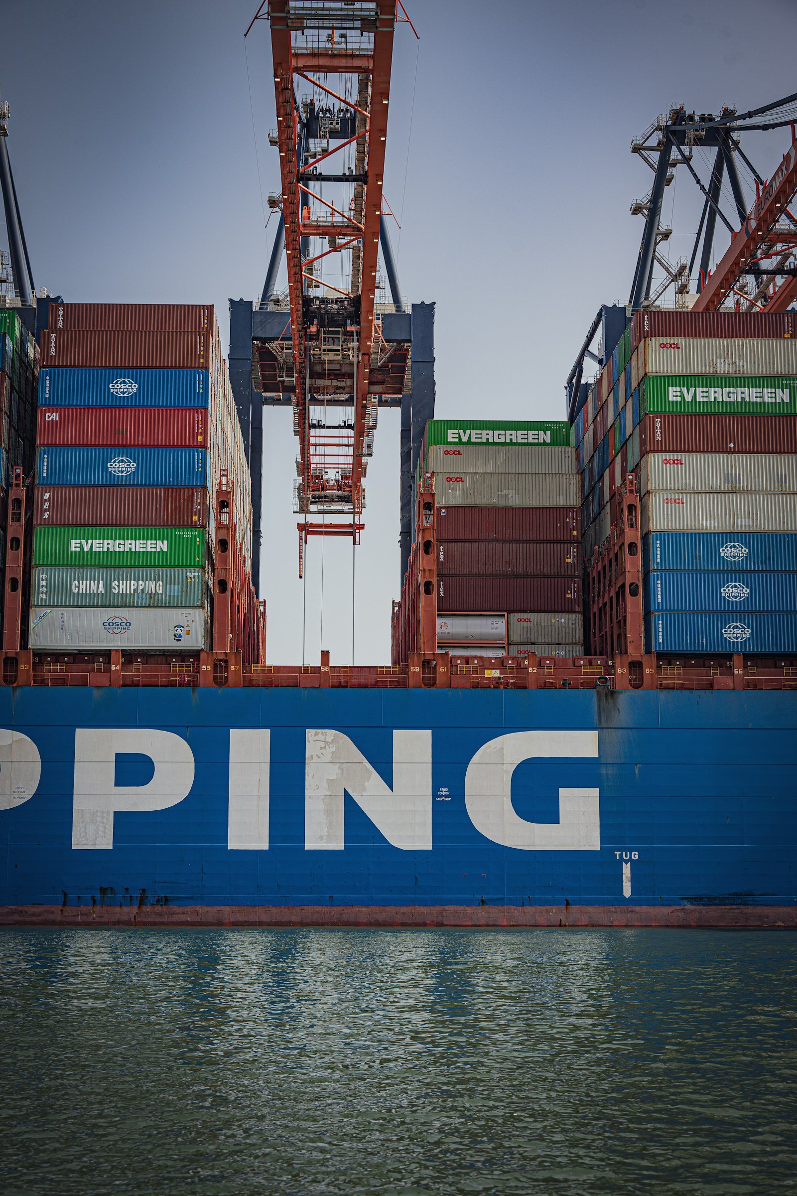 Cargo ship loaded with containers under a port crane