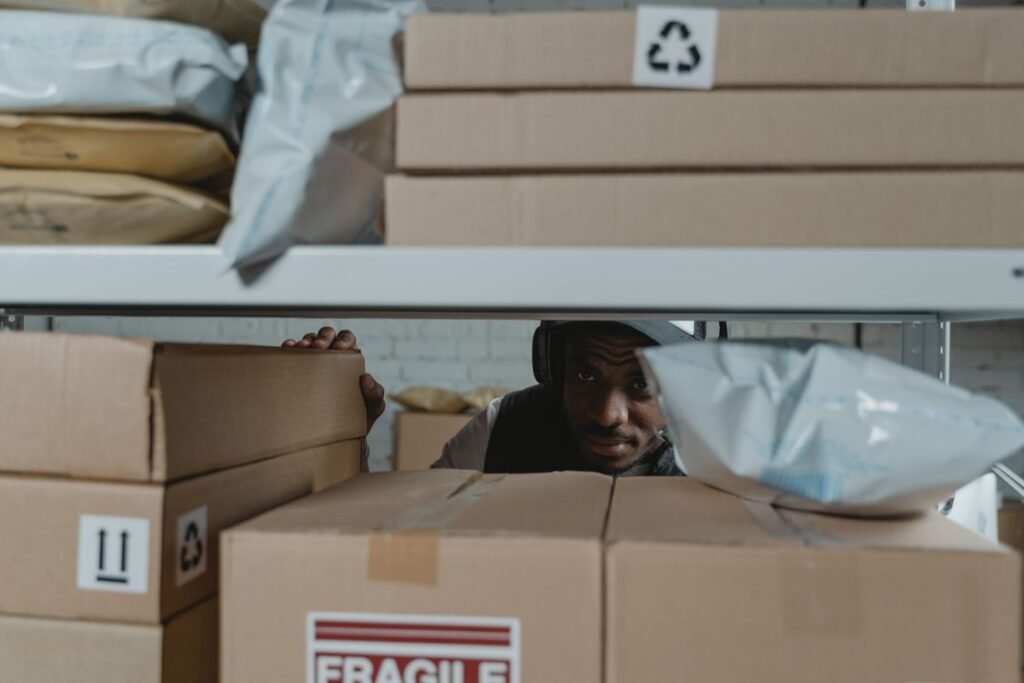 Warehouse worker inspecting packages on shelves for quality control