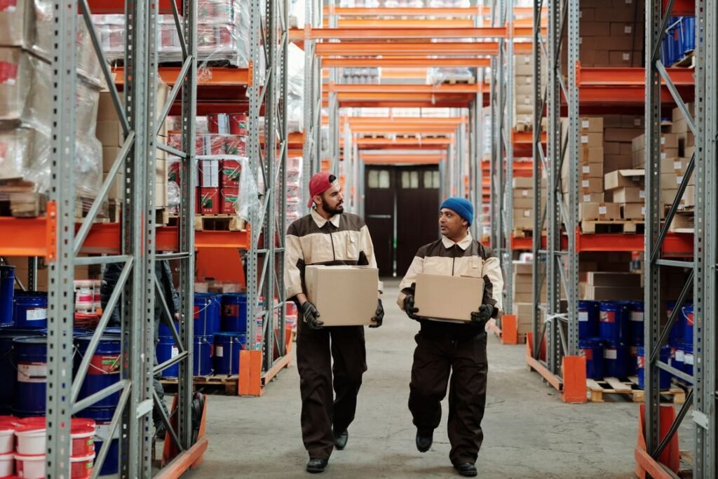 Warehouse workers coordinating and moving cartons for consolidation