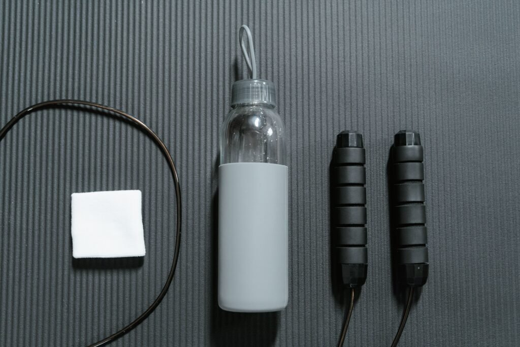 Workout essentials including water bottle and jump rope arranged flat lay